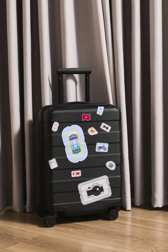 Travel suitcase decorated with custom stickers and graphic badges for Glomad.