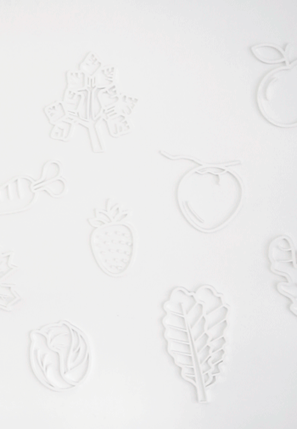 Subtle embossed fruit pattern on minimalist white packaging material for JUS.