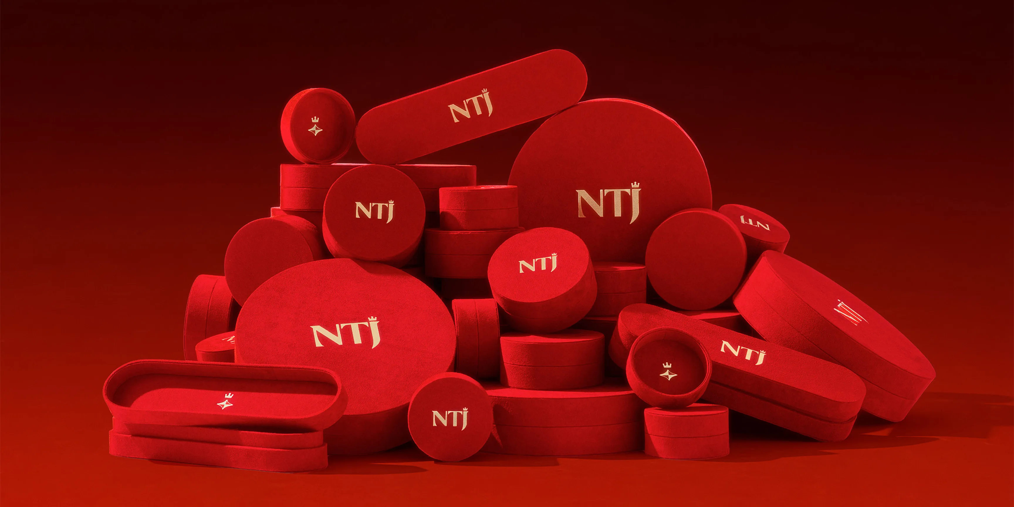Arrangement of luxury red circular packaging boxes stamped with the NTJ logo.